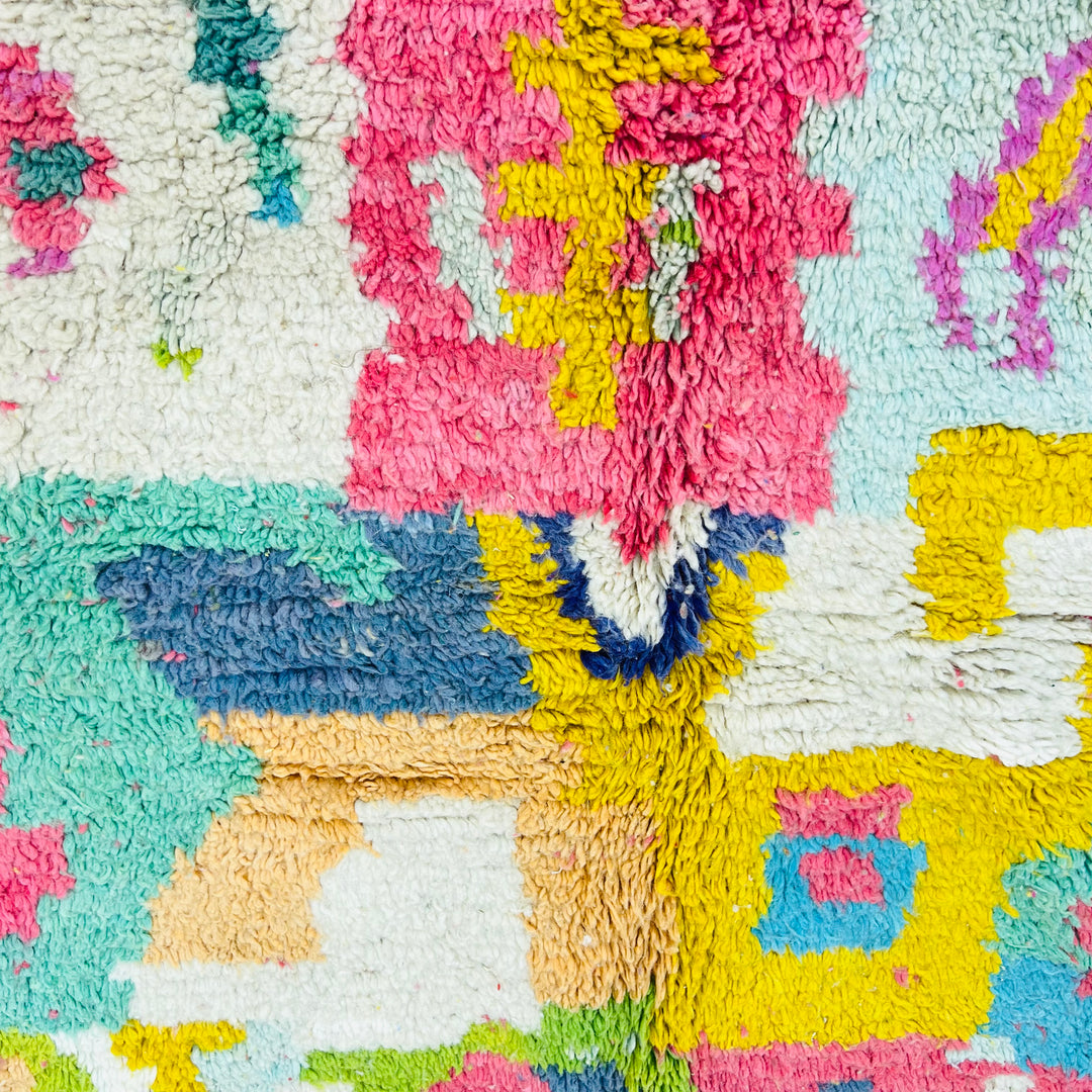 Colorful abstract Moroccan rug with vibrant pinks, blues, yellows, and greens. Handmade wool rug, perfect for boho or eclectic decor.