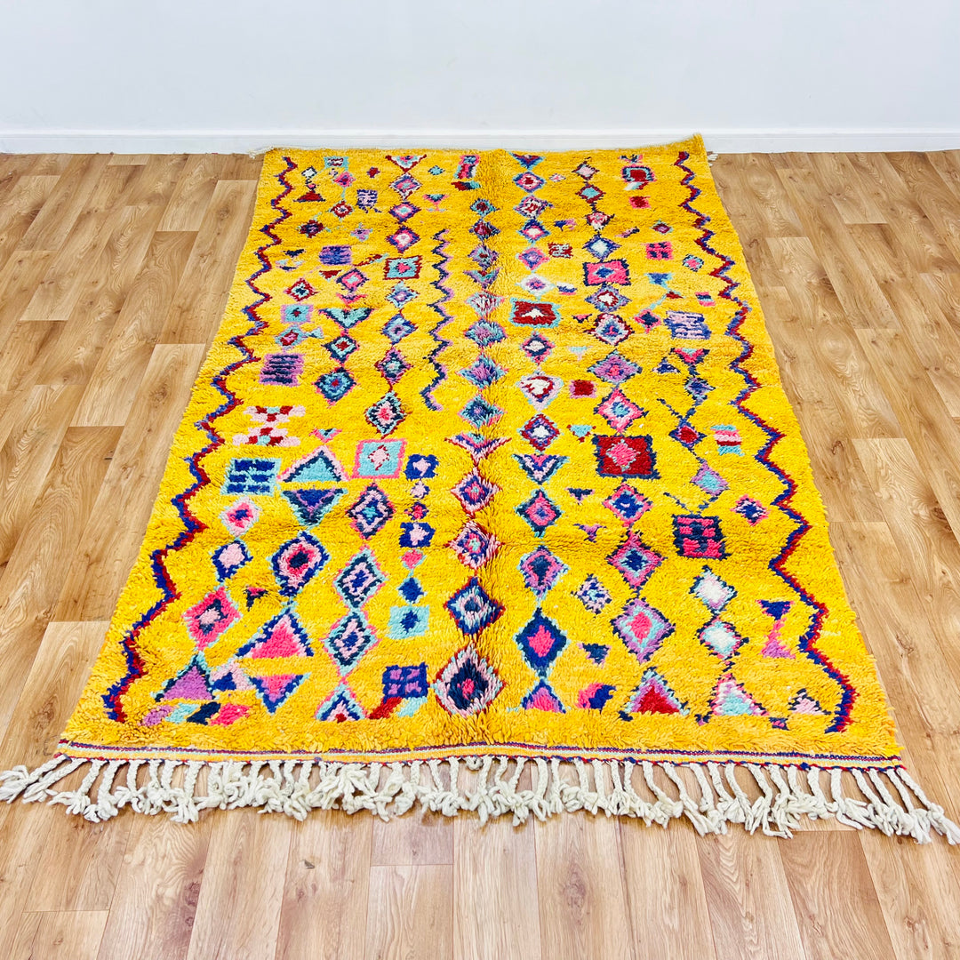 Yellow Moroccan Berber rug 254x157 cm with colorful geometric and tribal patterns. Vintage Moroccan wool area rug for sale.