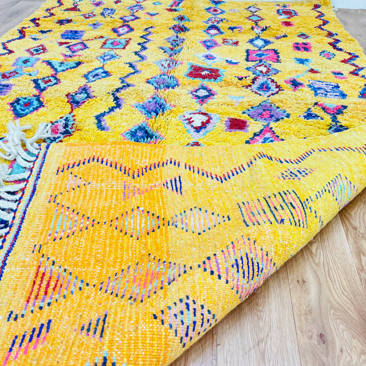 Yellow Moroccan Berber rug, 254x157 cm, featuring colorful geometric and tribal symbols. Handwoven traditional Moroccan wool rug.