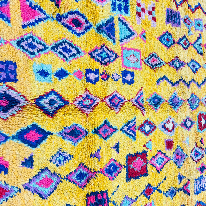 Vibrant yellow Moroccan Berber rug with colorful geometric designs, handwoven for a bold cultural touch.