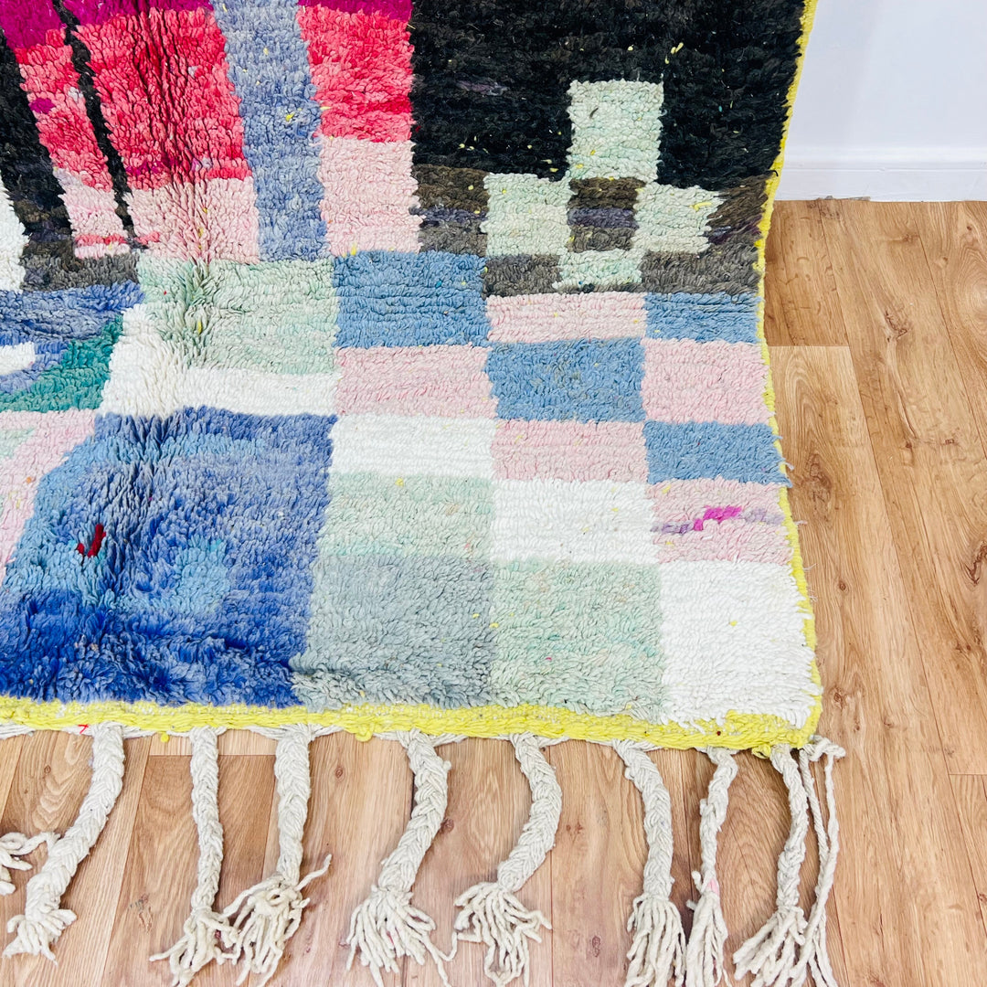 Vintage Moroccan rug with colorful abstract geometric design on wooden floor, handmade by Berber artisans, 100% wool, 263x169 cm.