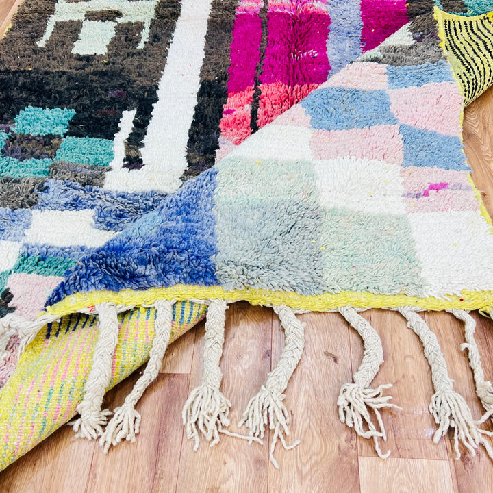 Colorful vintage Moroccan wool rug with geometric patterns and tassels, showcasing traditional Berber craftsmanship.