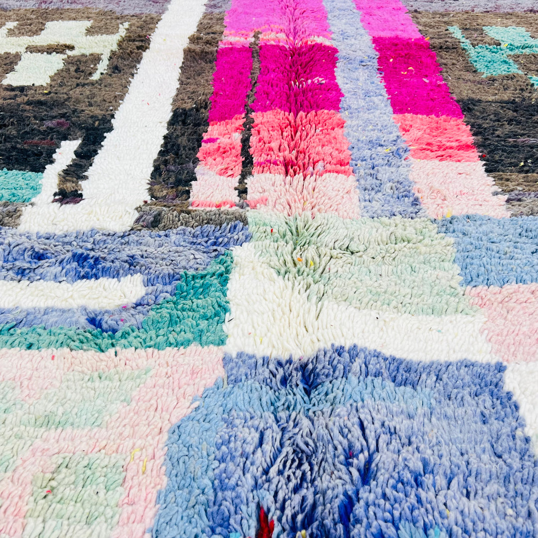 Colorful abstract vintage Moroccan rug with geometric shapes in blue, pink, and earthy tones. Handmade wool, 263 x 169 cm.