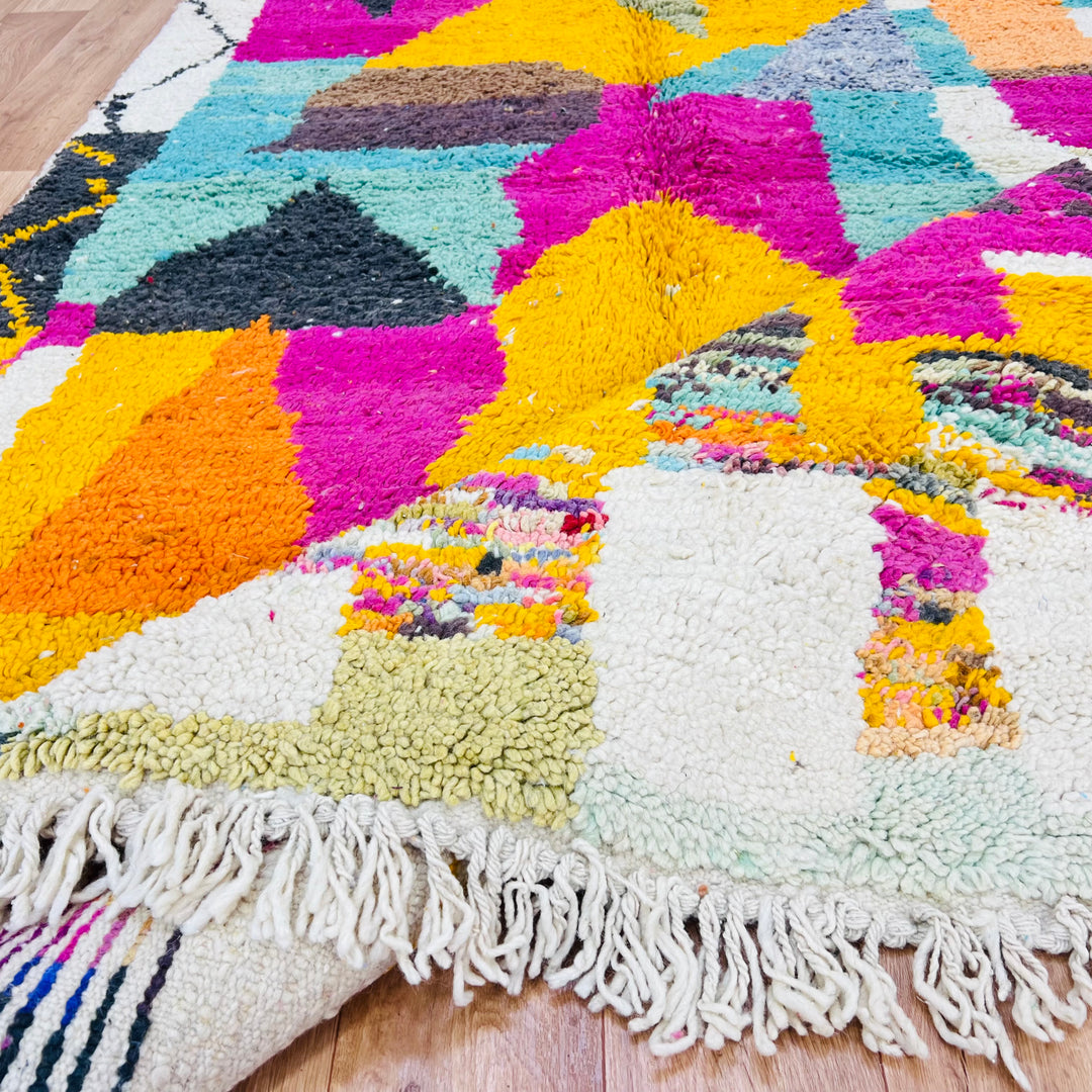 Colorful vintage Moroccan rug with abstract patterns, featuring magenta, mustard yellow, teal, and cream, handwoven by Berber artisans.