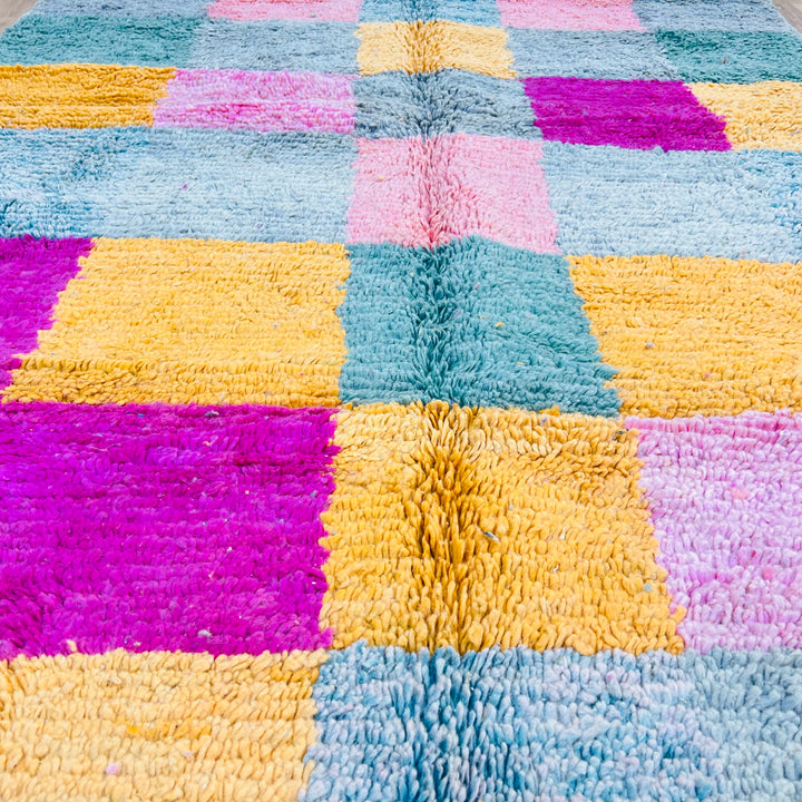Vintage Moroccan rug in vivid pink, mustard, green tones, handwoven by Berber artisans; perfect for eclectic or bohemian interiors.