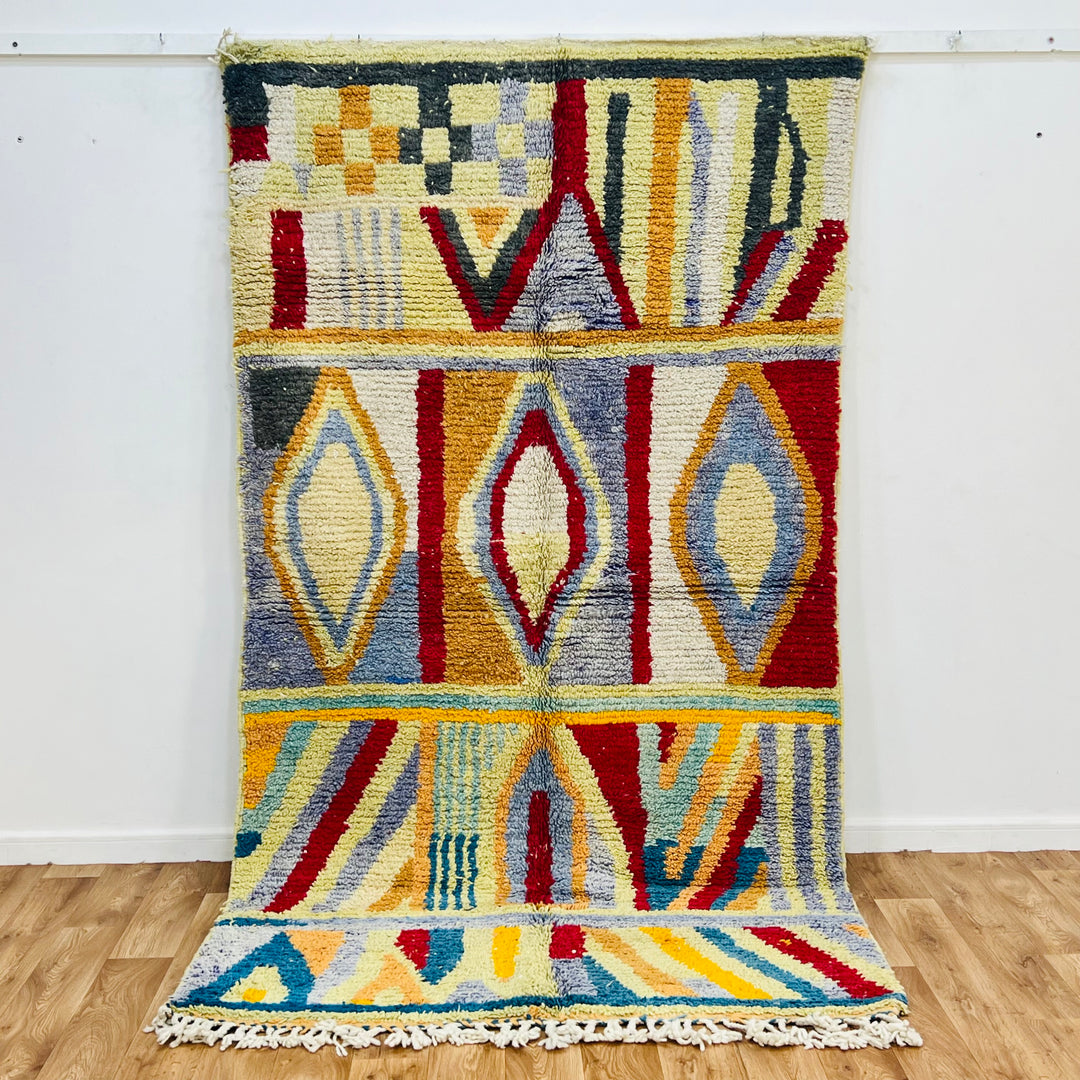 Vintage Moroccan rug with colorful Berber design, geometric patterns in red, blue, yellow, cream. Handwoven wool Moroccan rug.