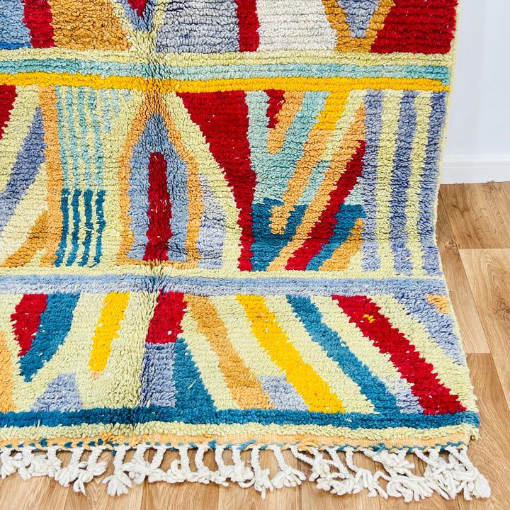 Rare colorful Moroccan Berber rug with vibrant geometric patterns in reds, blues, and yellows, handwoven wool from the Atlas Mountains.