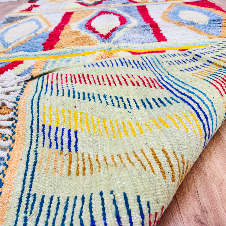 Colorful vintage Moroccan Berber rug with vibrant geometric patterns, handmade in the Atlas Mountains. Unique cultural craftsmanship.