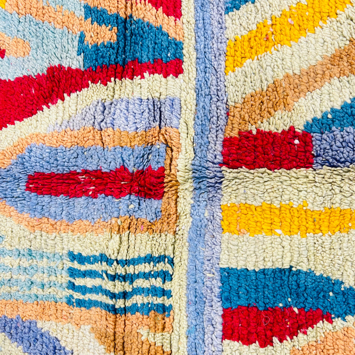 Vintage Moroccan Berber rug with vibrant geometric patterns in red, blue, and yellow. Handwoven wool rug, a cultural masterpiece.