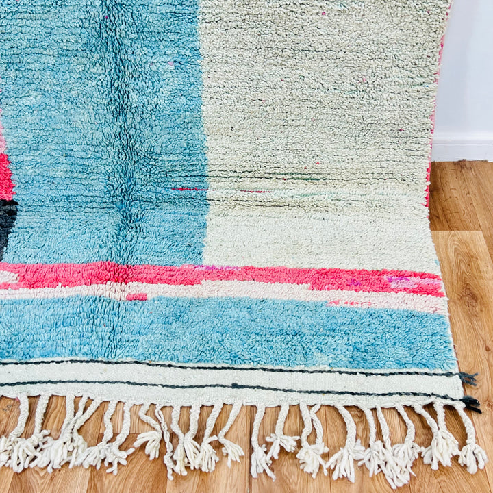 Handmade abstract pink and blue Moroccan Berber rug with fringe, showcasing unique patterns and natural wool material.