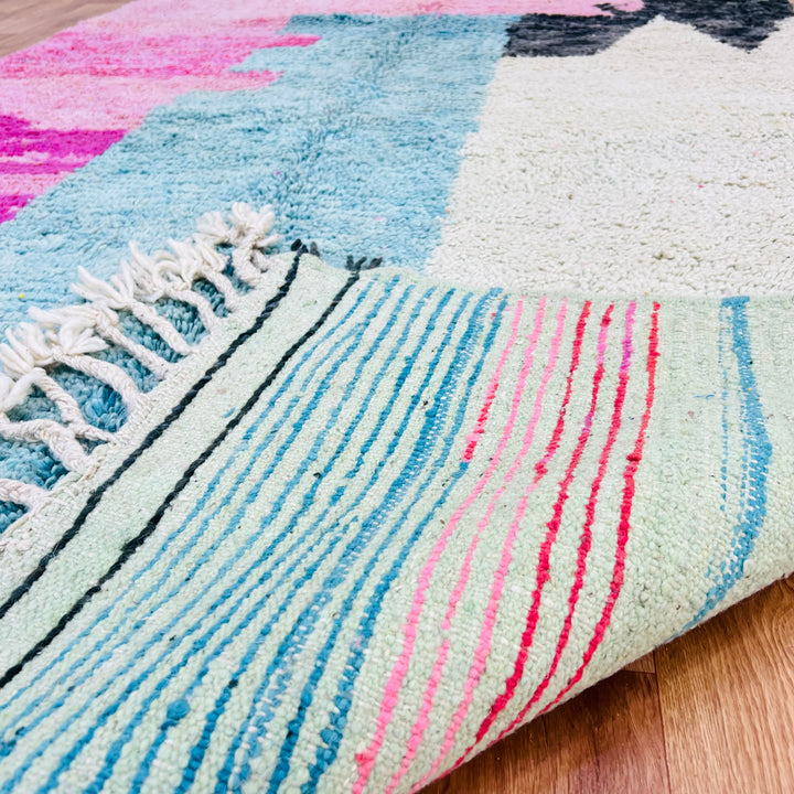 Abstract Moroccan rug in pink, blue, and ivory, showcasing Berber artistry and storytelling. Handmade with natural wool, 8x5 ft.
