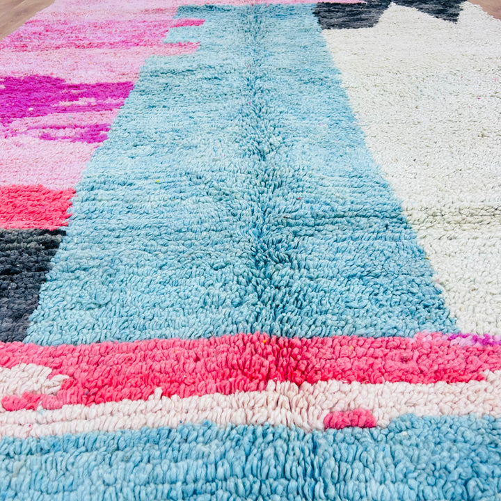 Abstract pink Moroccan Berber wool rug featuring blue, pink, and ivory, perfect for adding vintage style to any room.