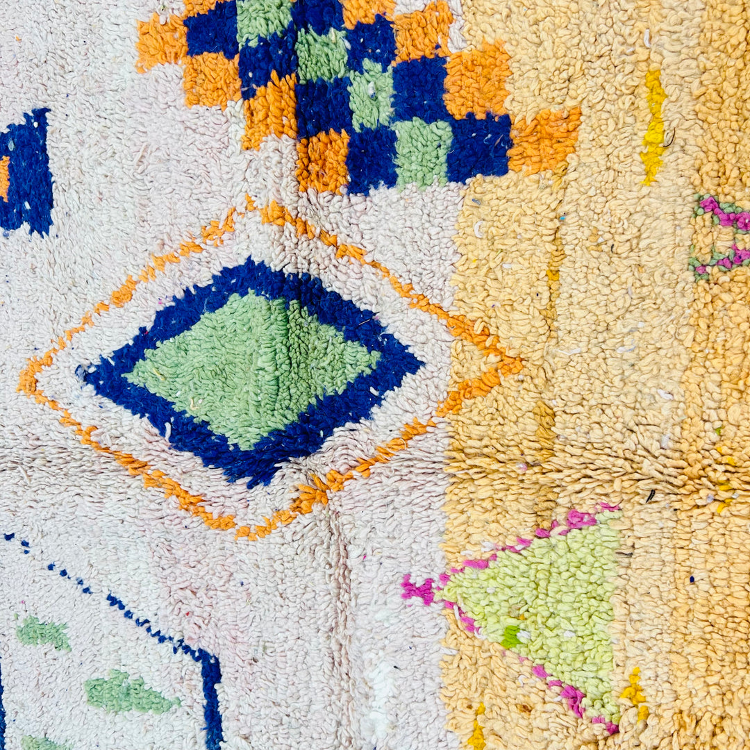 Colorful tribal diamond Moroccan rug, handwoven with vibrant Berber symbols, measuring 248x150 cm, soft peach base, wool texture.