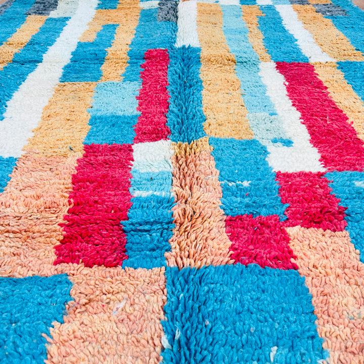 Vintage Moroccan rug with vibrant stripes in turquoise, ochre, red, and cream. Handwoven Berber artistry from Morocco.
