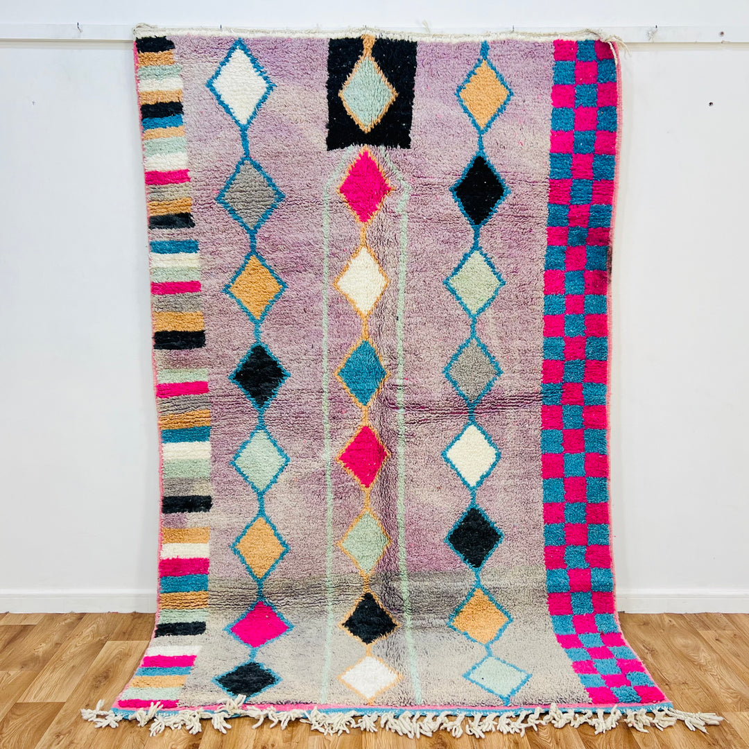 Vintage Moroccan rug with diamond and checker patterns, lavender base with pink, blue, and ochre accents, handmade Berber design.