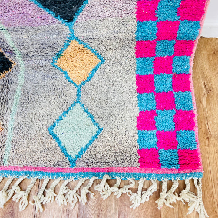 Handmade vintage Moroccan Berber rug with diamond patterns, pink and blue checkerboard, and fringe, perfect for modern decor.