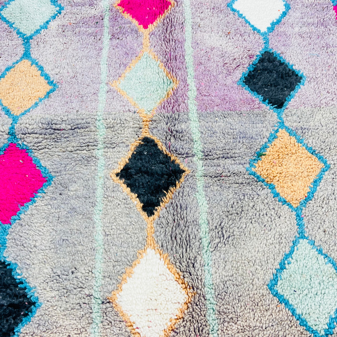 Vintage Moroccan rug with diamond, checker patterns in pink, blue on lavender base, handmade by Berber women, wool texture.
