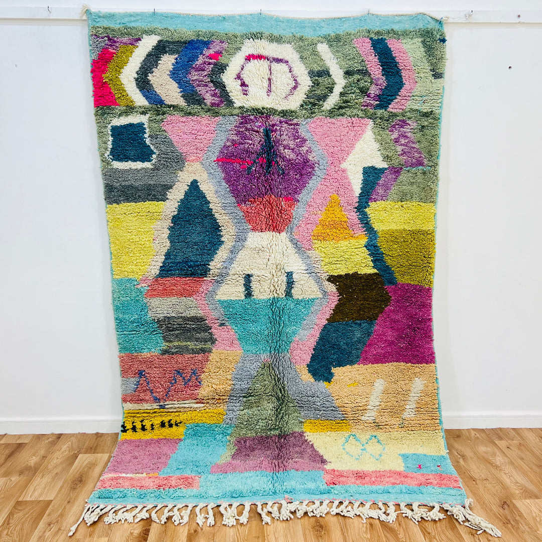 Colorful geometric Moroccan rug, 8.03 x 5.18 ft, handwoven by Berber artisans, featuring vibrant abstract motifs in wool.