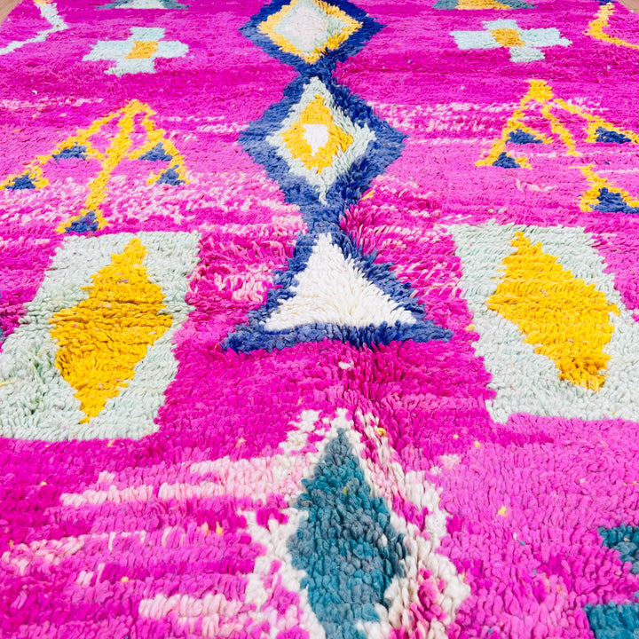 Pink Moroccan Berber rug with tribal symbols in mustard, teal, and navy. Vibrant wool area rug, 164x155 cm. Traditional Moroccan style.