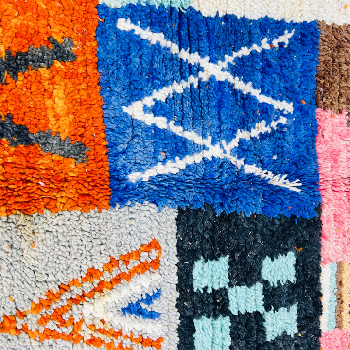Colorful Moroccan patchwork wool rug with tribal symbols in red, blue, amber, ivory; handmade Berber artistry, 249x149 cm.