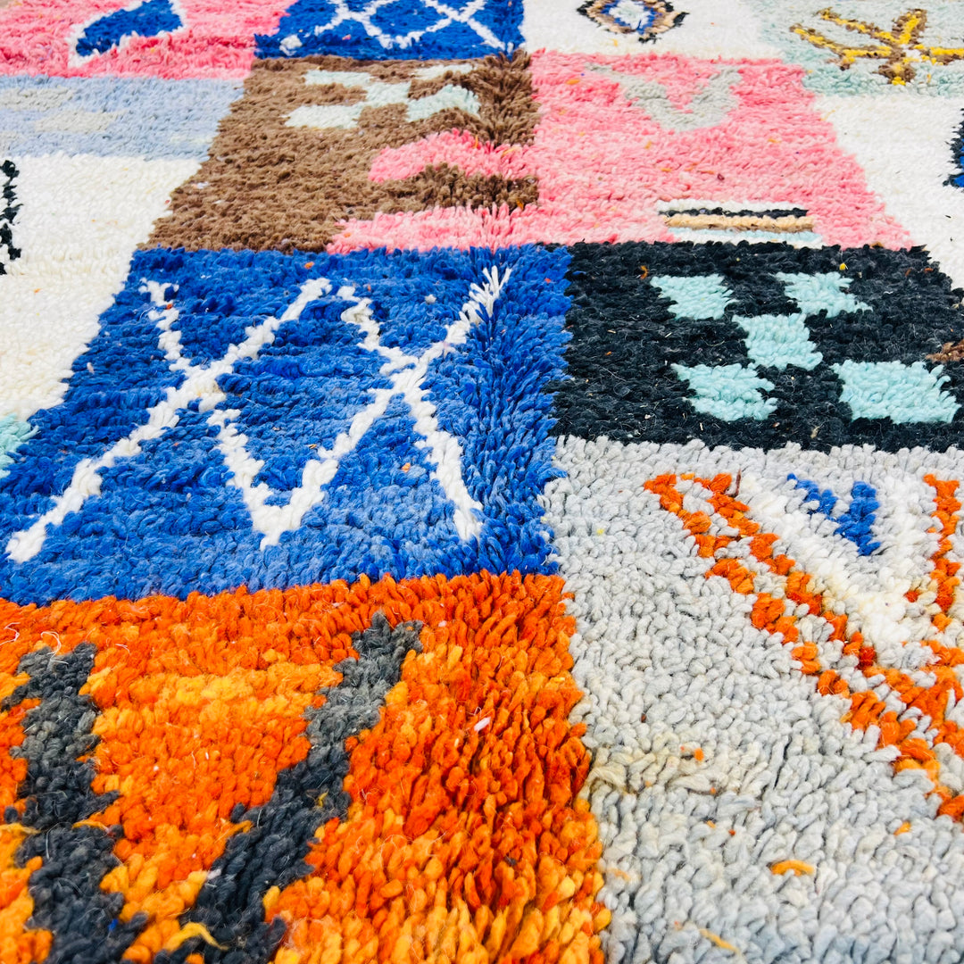 Colorful Moroccan patchwork wool rug with tribal symbols, featuring red, blue, amber, and ivory. Handmade Berber artistry. Size: 249x149 cm.