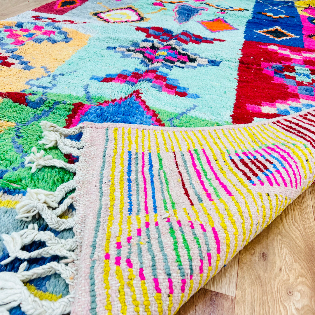 Colorful vintage Moroccan rug with bold geometric patterns and vibrant colors, handcrafted using traditional Berber techniques.