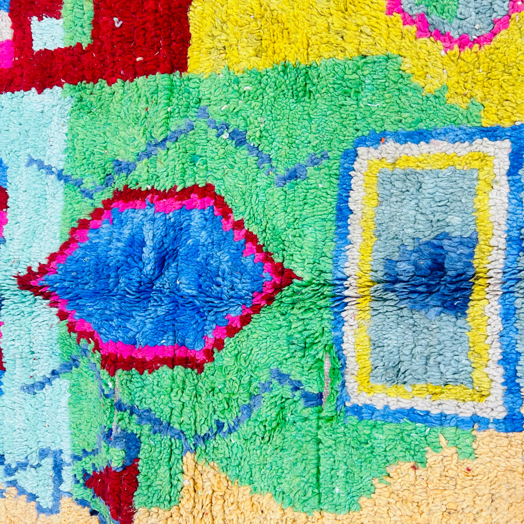Colorful vintage Moroccan Berber rug with geometric patterns in pink, turquoise, orange, and blue. Handcrafted 100% wool.