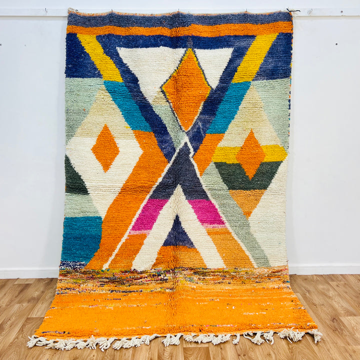Large colorful Moroccan wool rug with geometric patterns in orange, navy, fuchsia; handwoven by Berber artisans. Size 255x171 cm.