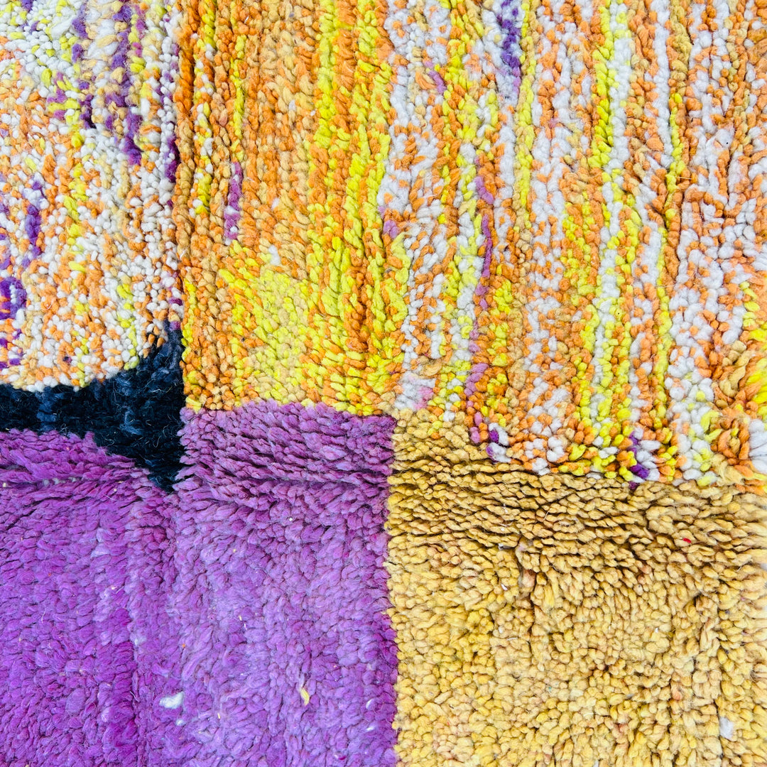 Vintage Moroccan Sunset Rug displaying purple, yellow, and orange textures, capturing the essence of a desert sunset. 238x161 cm.