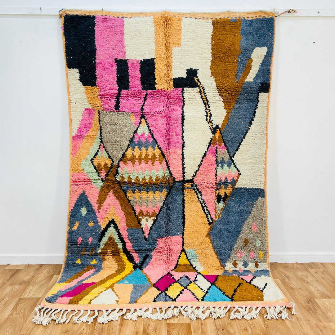 Colorful vintage Moroccan wool rug with geometric diamond pattern, pink, cream, mustard, blue, and orange hues, size 256x169 cm.