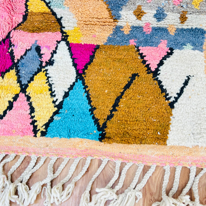 Colorful vintage Moroccan Berber wool rug with geometric diamond pattern in pink, cream, mustard, blue, and orange hues.