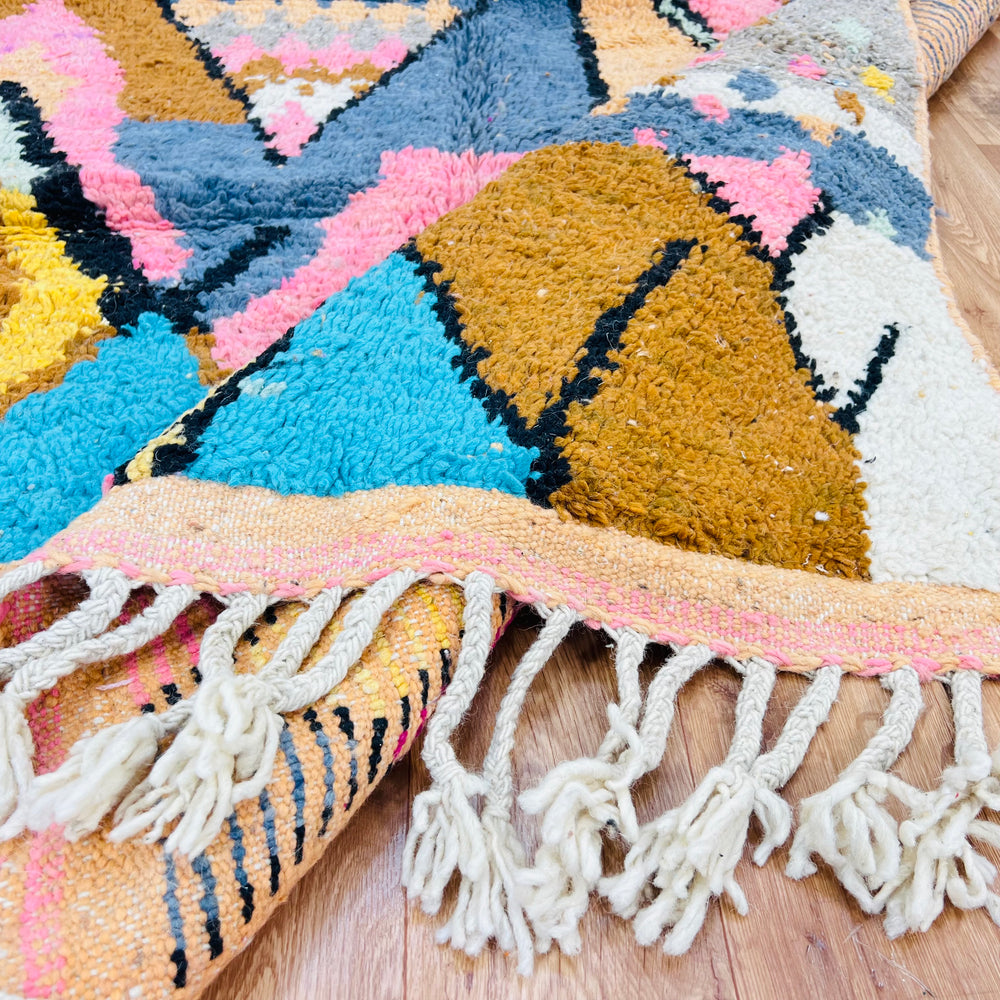 Colorful vintage Moroccan wool rug with geometric diamond pattern in pink, mustard, blue, and orange hues, perfect for boho decor.