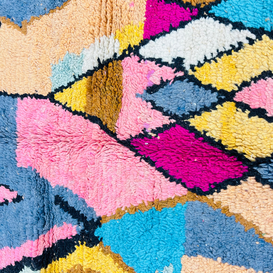 Colorful geometric Moroccan Berber wool rug with pink, cream, mustard, blue hues. Traditional design ideal for boho interiors.