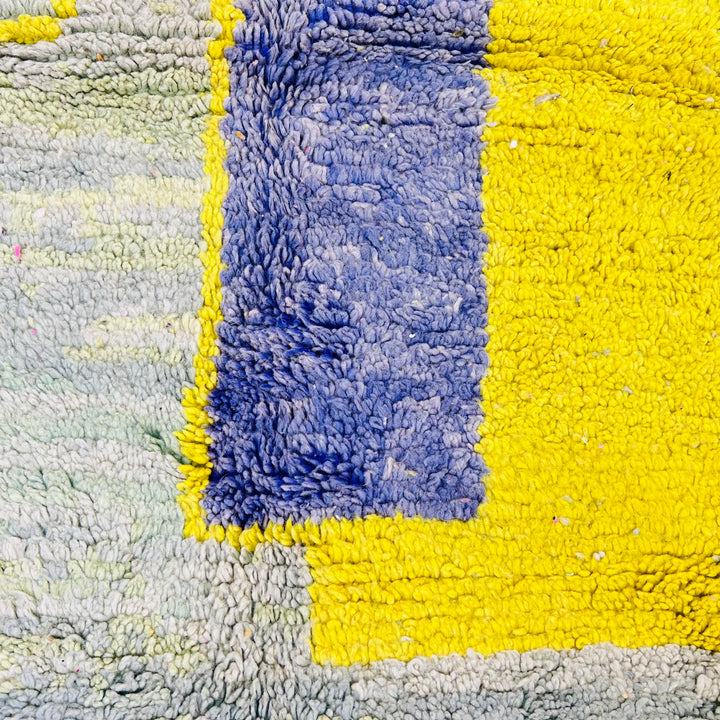 Yellow Moroccan wool rug with tribal abstract design featuring mustard, indigo, and olive green. Handmade area rug from Morocco.
