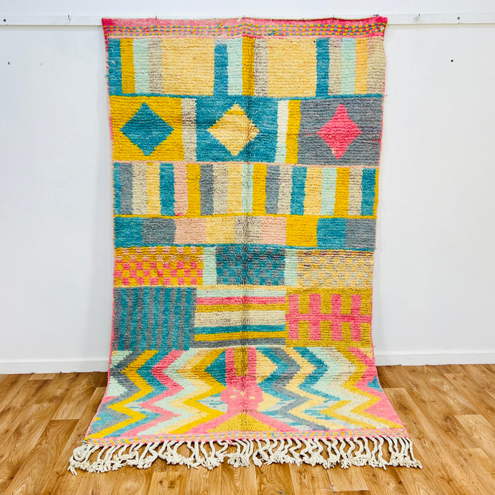 Vintage Moroccan Wool Rug 406 – handmade colorful geometric Moroccan rug in yellow, teal, pink, and gray tones (256 × 150 cm).