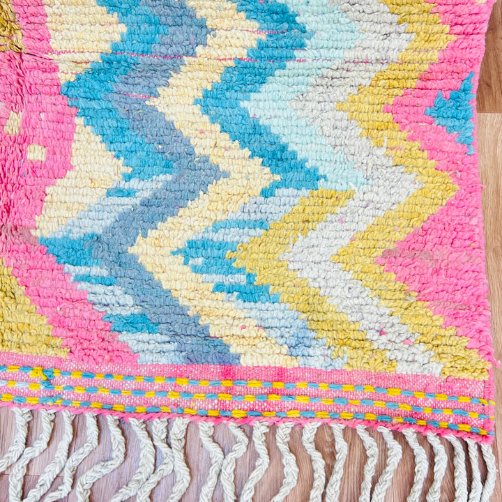 Colorful vintage Moroccan wool rug with Berber designs in yellow, pink, teal, and grey. Handwoven in the Atlas Mountains.