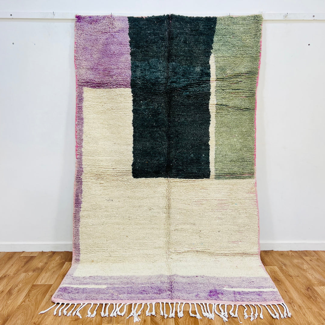 Modern geometric Moroccan rug in green, sage, purple, and ivory tones, featuring bold blocks and a soft wool texture. 259x154 cm.