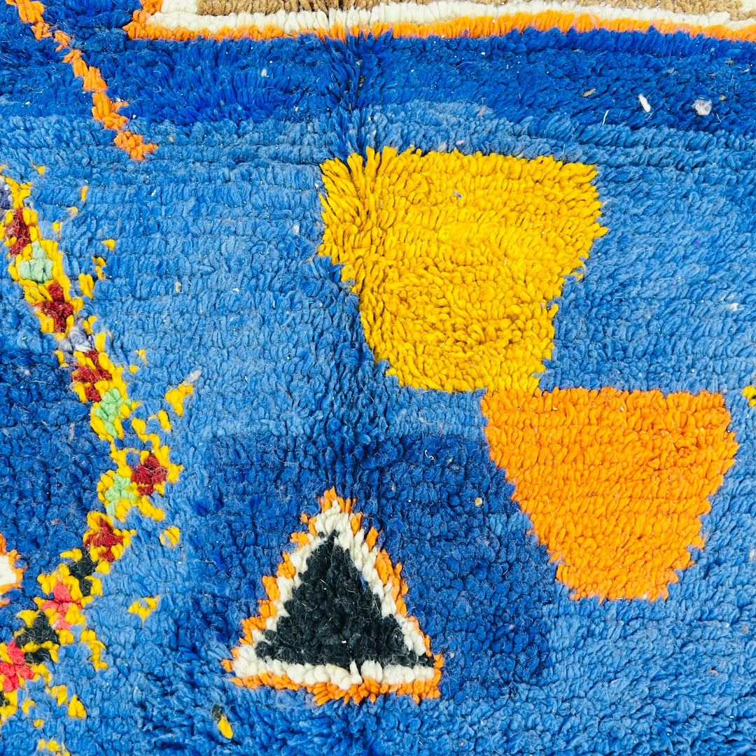 Handmade blue vintage Moroccan rug with vibrant colors and Berber symbols like diamonds and tribal shapes.