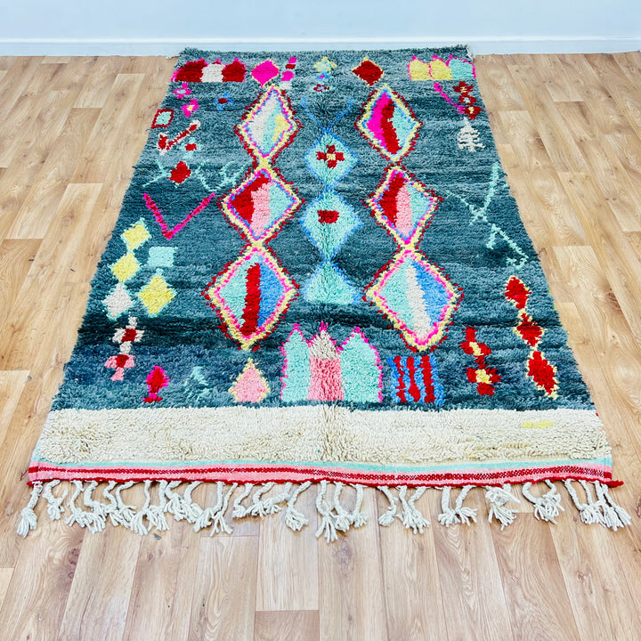 Vintage Moroccan rug with green background and vibrant diamond motifs, 258x151 cm, handwoven by Berber artisans, soft wool.