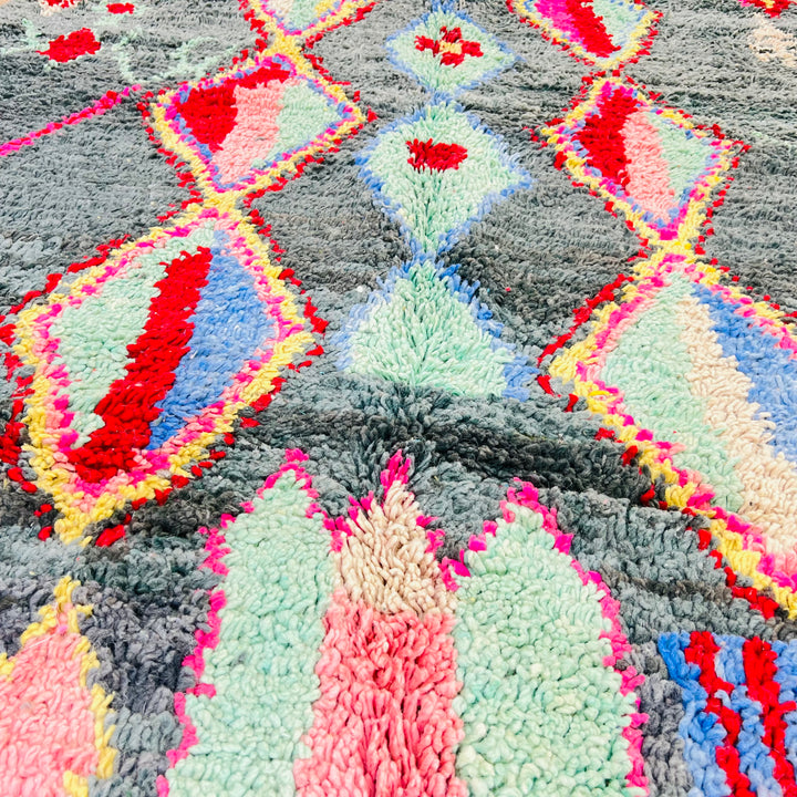 Vintage Moroccan diamond rug with vibrant red, pink, yellow, and blue on lush green, handwoven wool by Berber artisans.