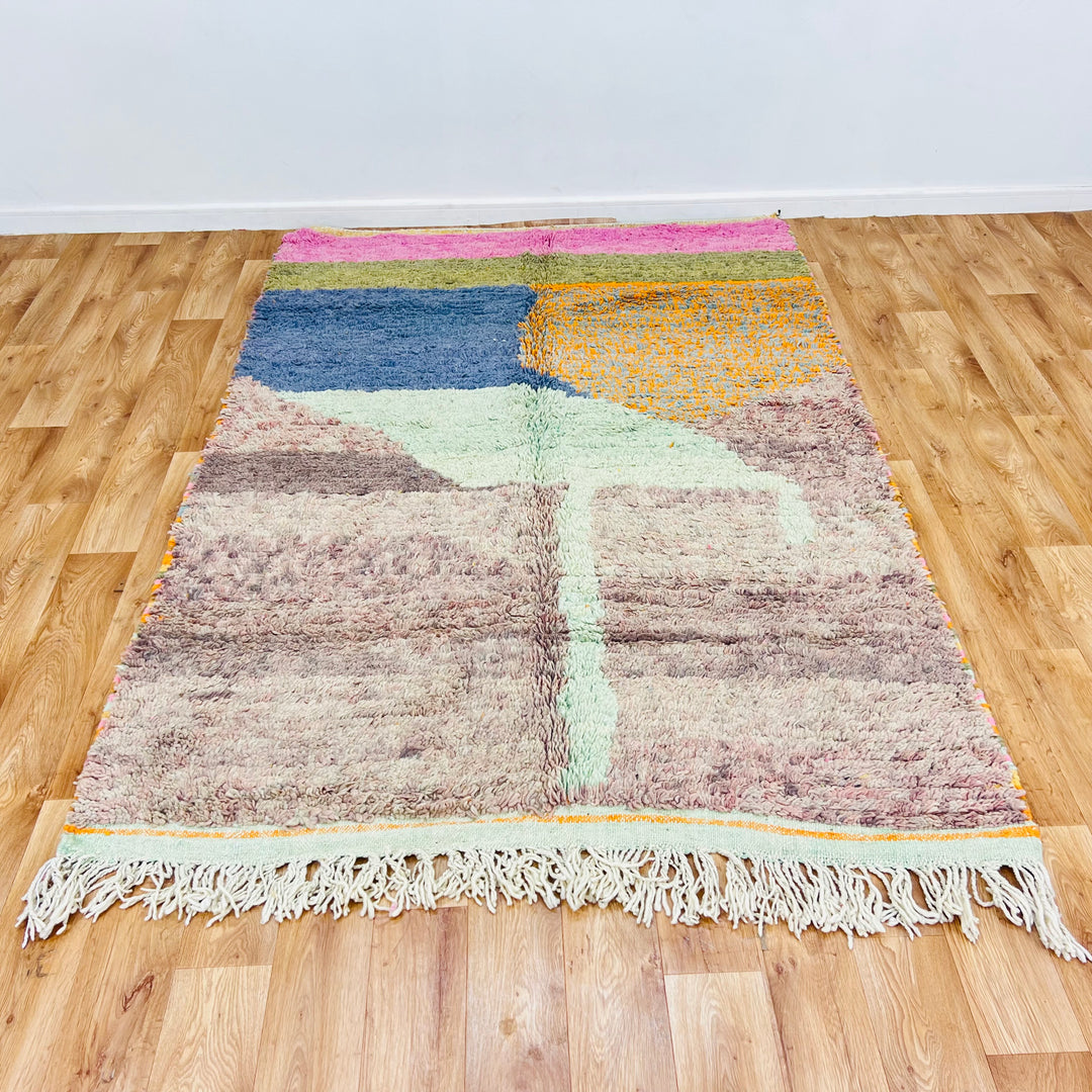 Abstract Moroccan wool rug, 229x160 cm, featuring a desert-inspired palette with deep blue, olive green, and dusty rose hues on hardwood floor.