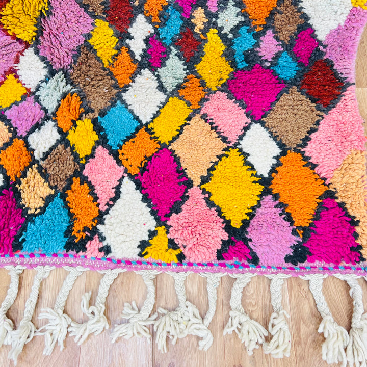 Vibrant Moroccan Berber rug with colorful diamond patterns, handwoven from wool, 8 x 10 feet, on wooden floor.
