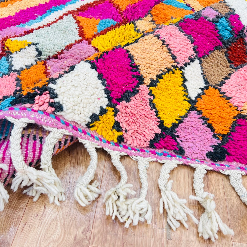 Colorful Moroccan Berber rug with vibrant diamond patterns in pink, orange, and turquoise, handwoven wool, perfect for a stylish area.