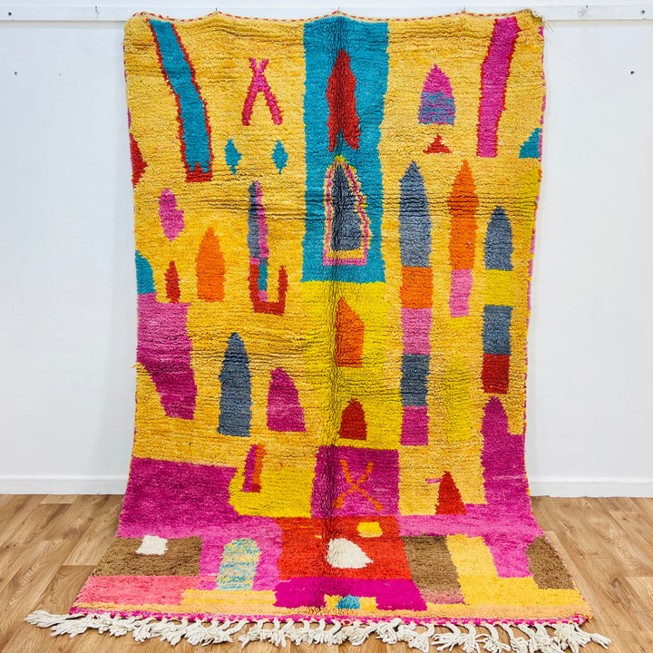 Colorful Moroccan shag rug with multicolored patterns and vibrant magenta, orange, and aqua tones, handmade from natural wool.