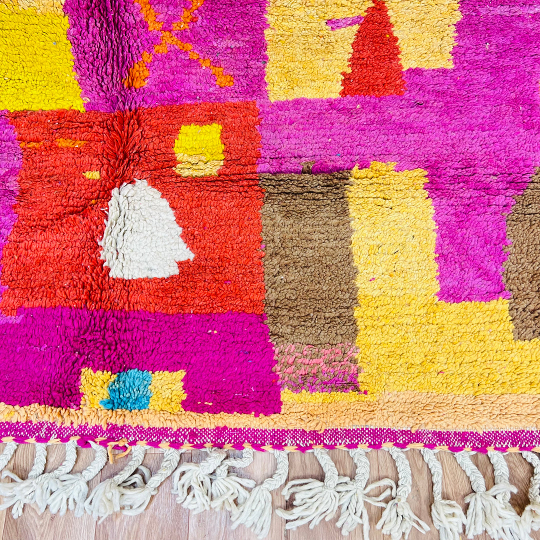 Colorful Moroccan shag rug with multicolored diamonds and abstract patterns in magenta, orange, aqua, and yellow, handmade from wool.