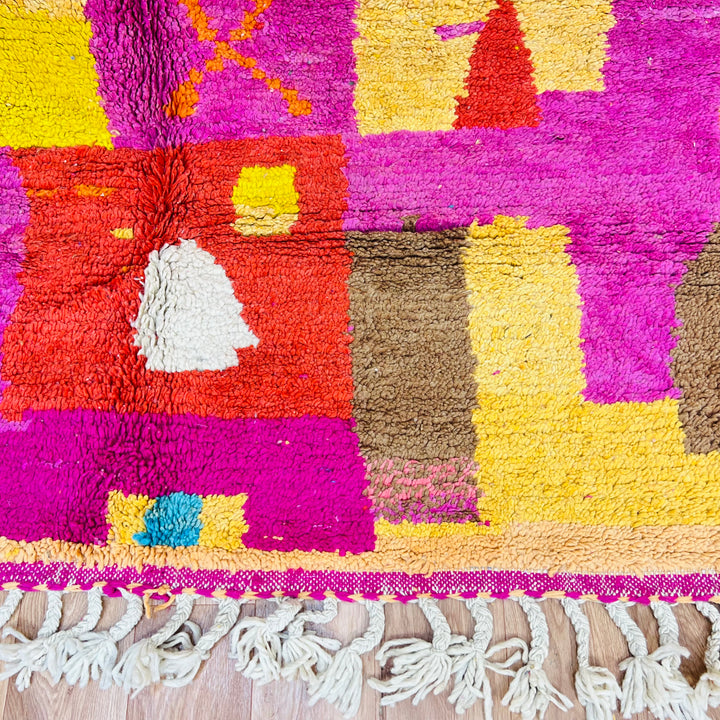 Colorful Moroccan shag rug with multicolored diamonds and abstract patterns in magenta, orange, aqua, and yellow, handmade from wool.