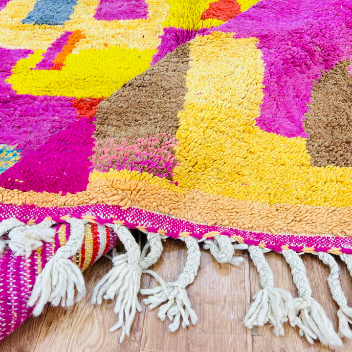 Colorful Moroccan shag rug with vibrant pink, yellow, and brown patterns, showcasing traditional Berber design.