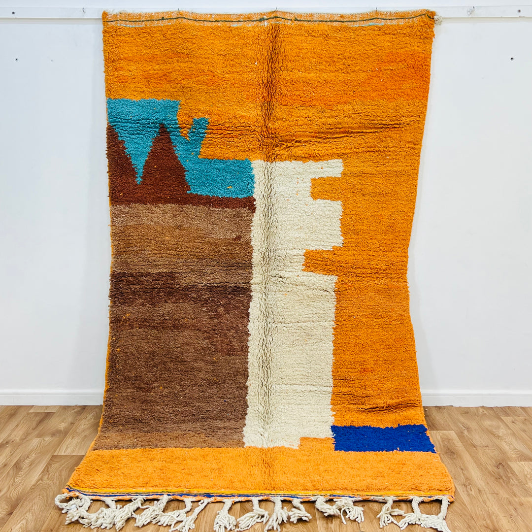 Colorful Moroccan wool rug with abstract motifs in orange, blue, and brown, handmade by Berber artisans. Size: 251 × 157 cm.