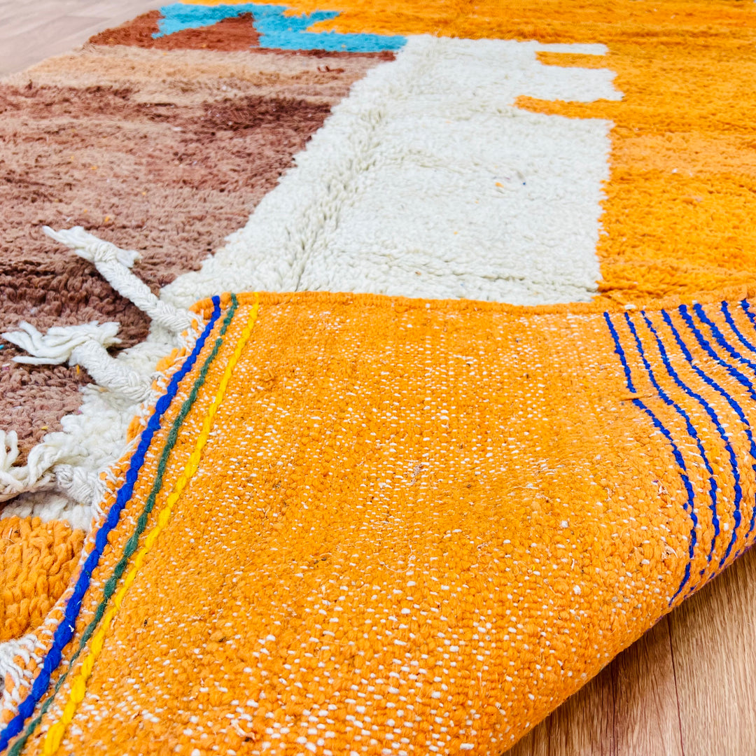 Close-up of a colorful Moroccan wool rug with vibrant patterns, handmade by Berber artisans. Dimensions: 251 × 157 cm.