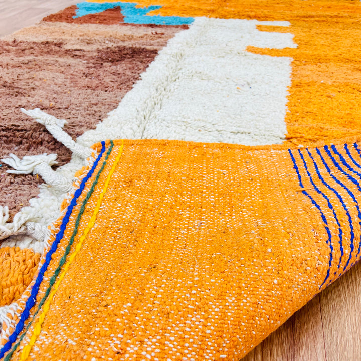 Close-up of a colorful Moroccan wool rug with vibrant patterns, handmade by Berber artisans. Dimensions: 251 × 157 cm.